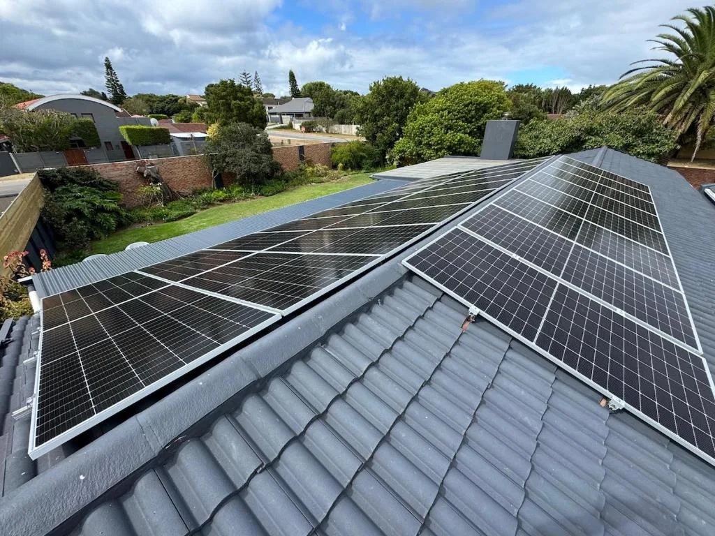 Solar panels installed on modern house roof with garden and countryside views