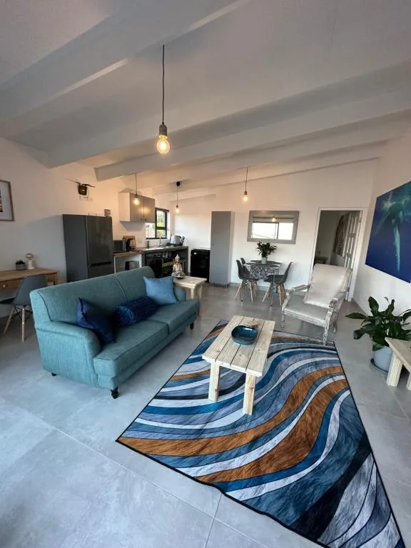 Open-plan lounge with blue sofa, pendant lighting, and modern decor throughout