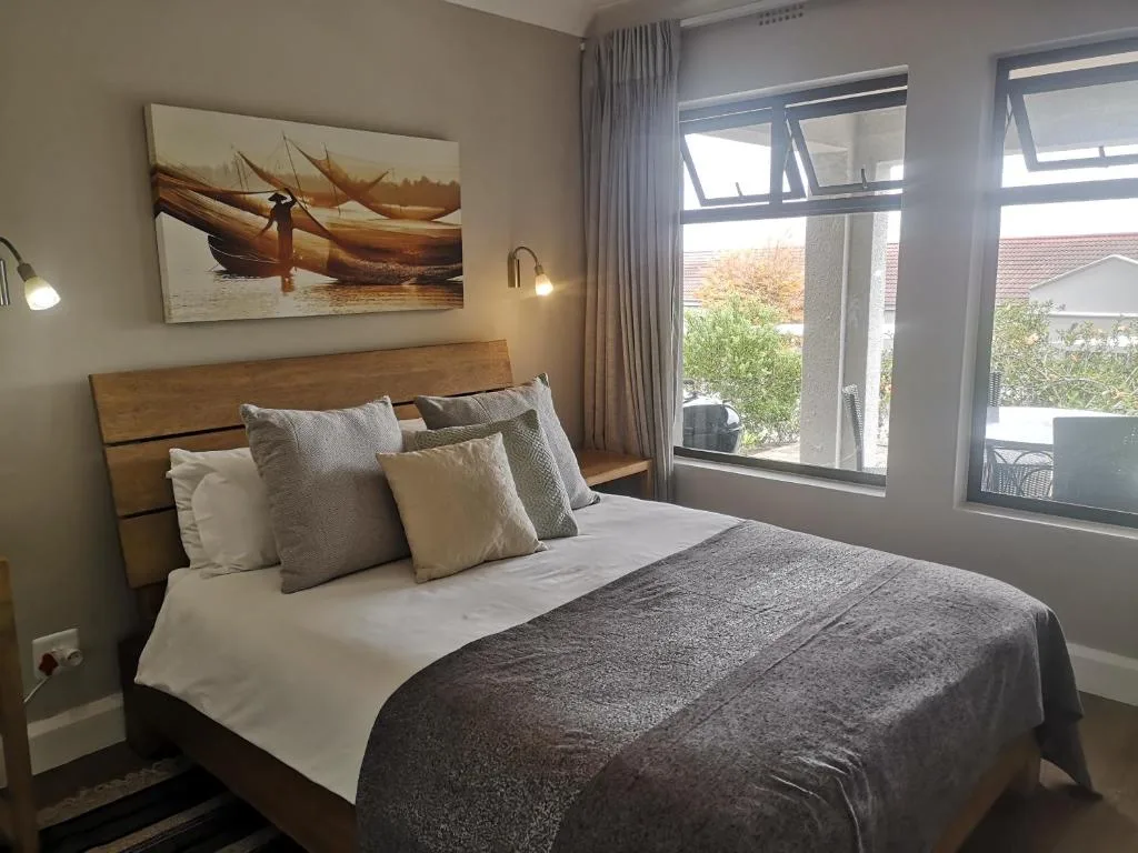 Spacious bedroom with wooden bed frame and garden views through large windows