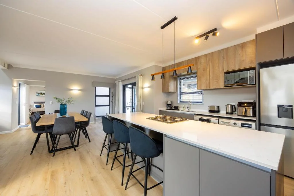 Modern kitchen with island, gas cooktop, pendant lights, and dining area