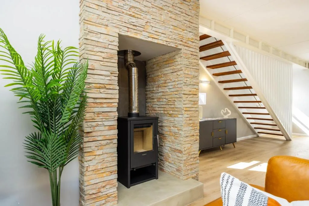 Modern lounge with wood-burning stove, stairs, and contemporary decor
