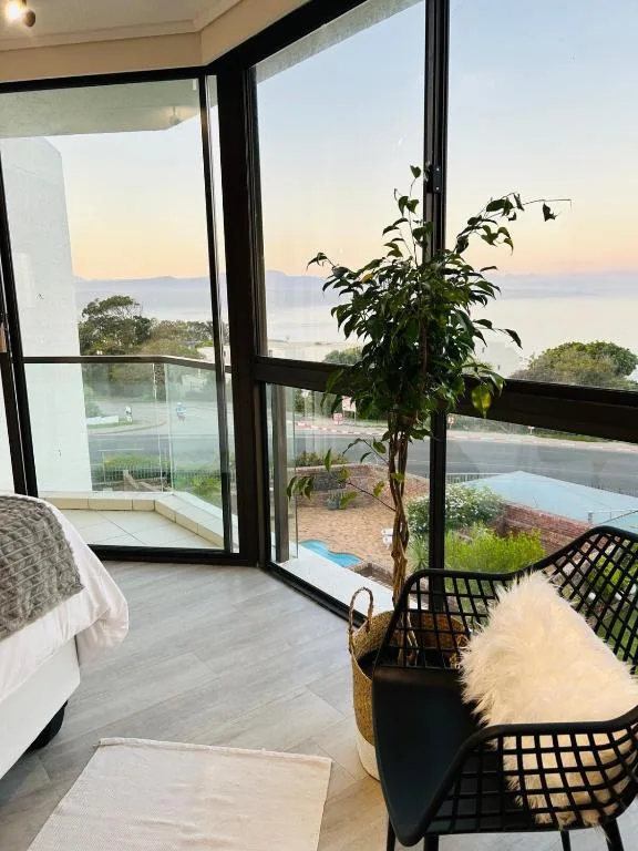 Sunrise over calm lagoon waters through floor-to-ceiling windows and doors