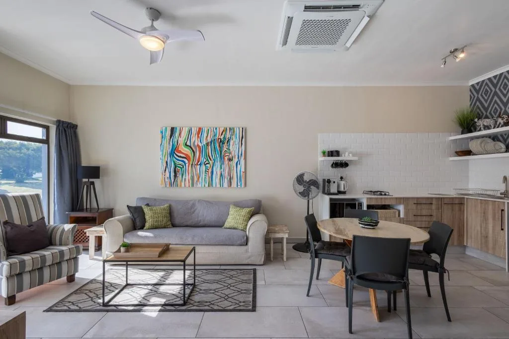 Modern lounge with gray sofa, striped armchair, and colorful abstract artwork