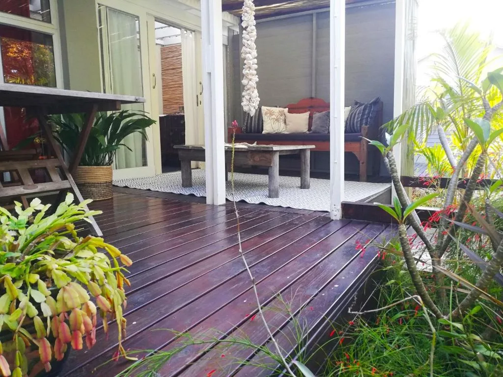 Wooden deck with potted plants and garden seating area overlooking property