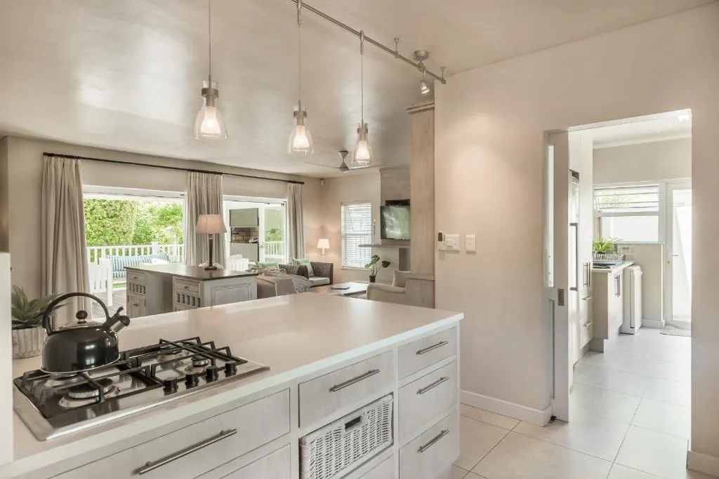 Modern kitchen with white cabinetry, gas cooktop, island, and pendant lighting