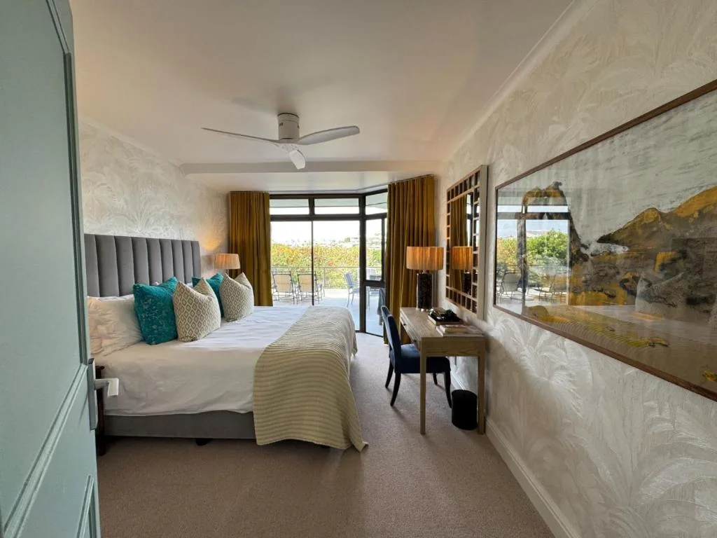 Spacious bedroom with upholstered headboard and garden view doors