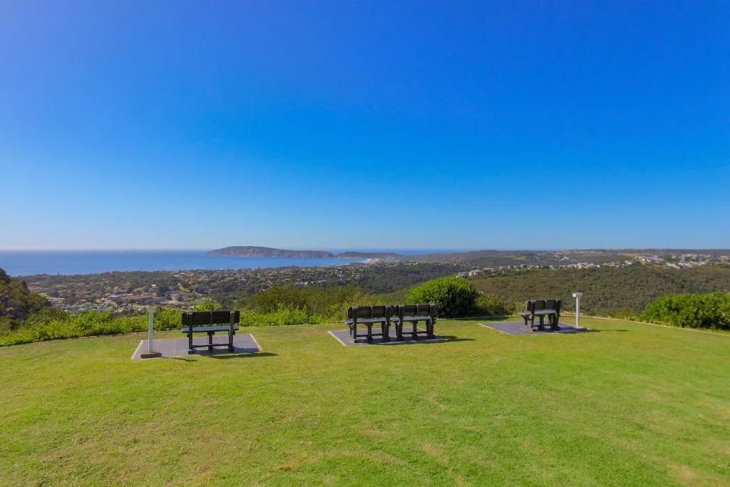 Expansive coastal landscape with islands, town, and braai stations overlooking ocean
