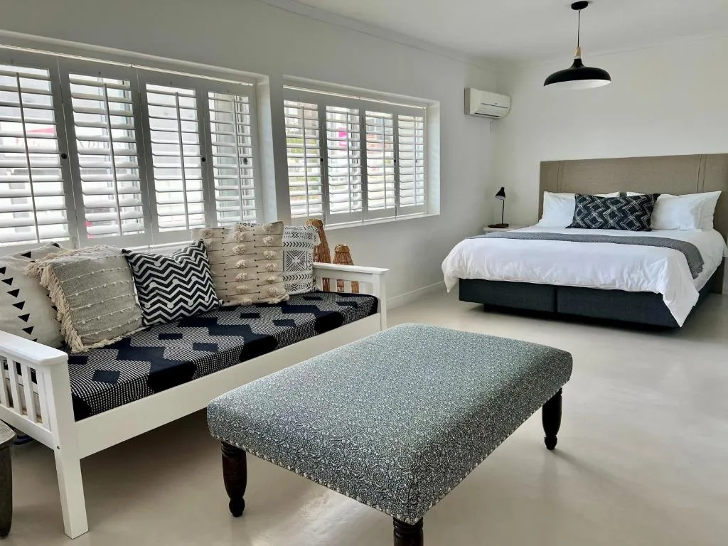 Modern bedroom with queen bed, window seat, and neutral decor