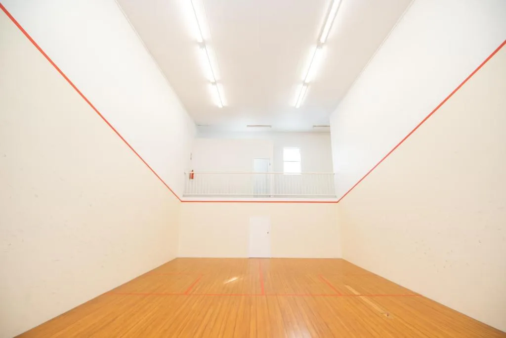Empty interior space with wooden flooring and mezzanine level above