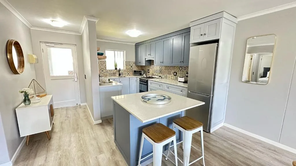 Modern kitchen with blue cabinetry, stainless steel appliances, and island seating