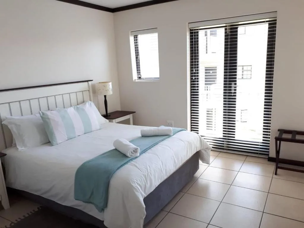 Bright bedroom with neatly made bed and modern sliding glass doors