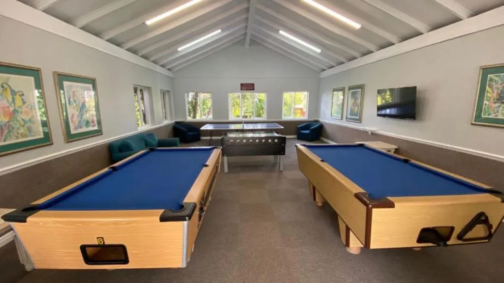 Game room with two pool tables, foosball table, and TV entertainment
