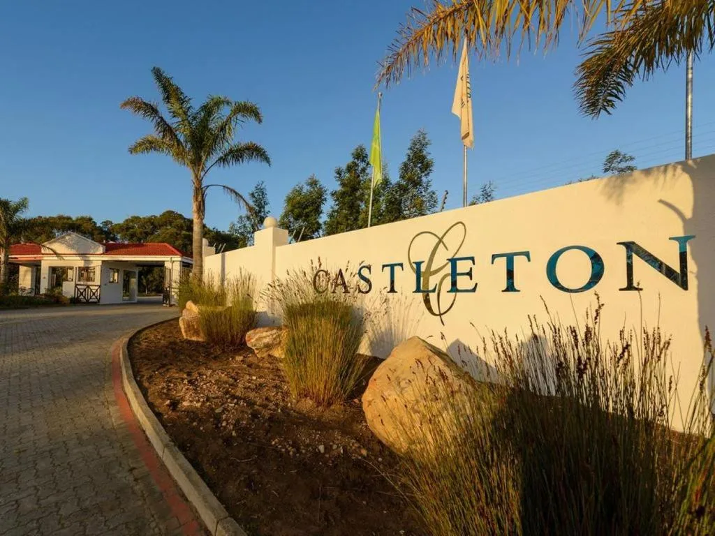 Castleton property entrance sign with palm trees and manicured gardens