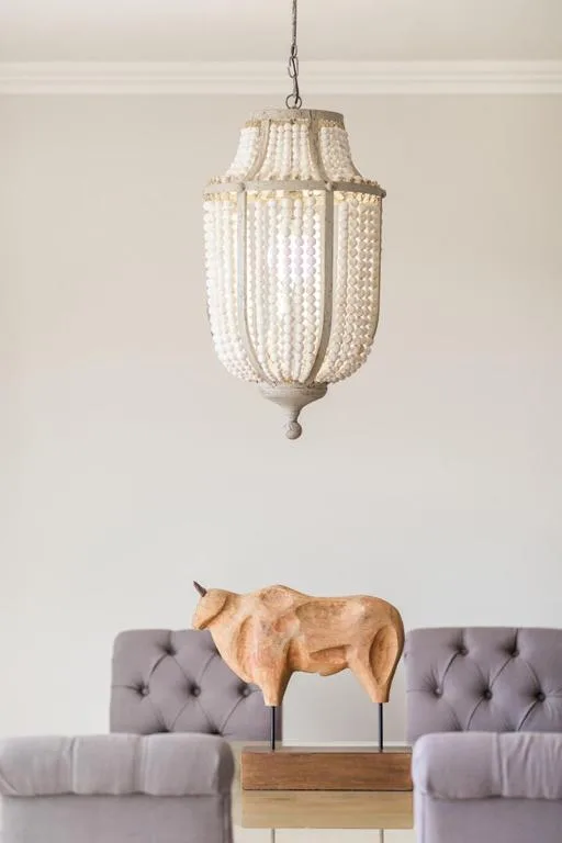 Modern lounge with gray tufted sofa and beaded pendant light fixture