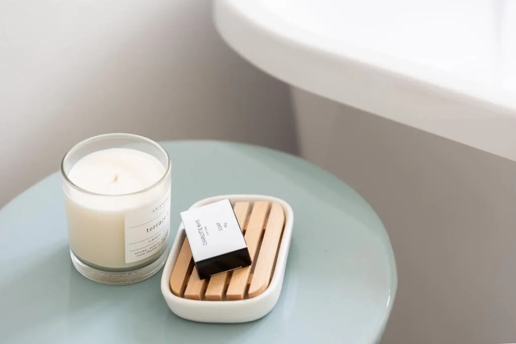Luxury bathroom amenities including scented candle and soap on table