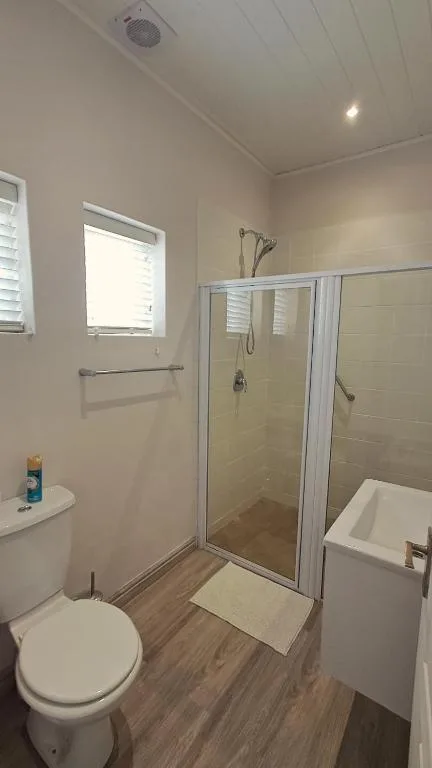 Clean bathroom with shower enclosure, toilet, and vanity sink