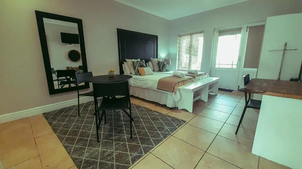 Spacious bedroom with double bed, work desk, and sliding glass doors