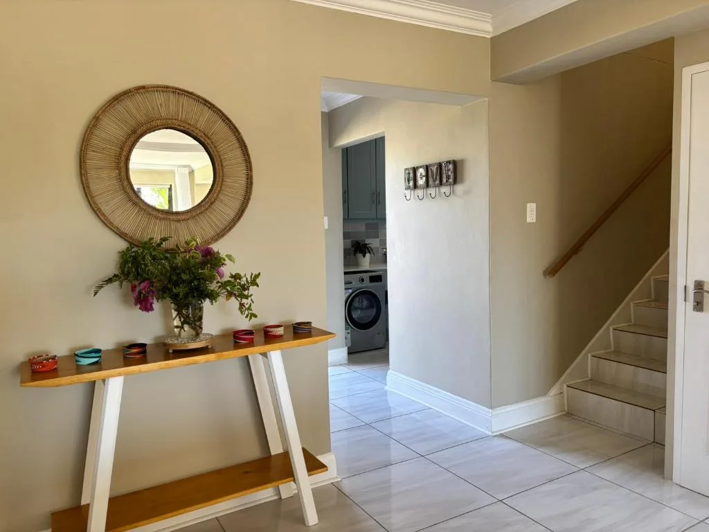 Hallway entrance with decorative mirror, console table, and fresh flowers arrangement