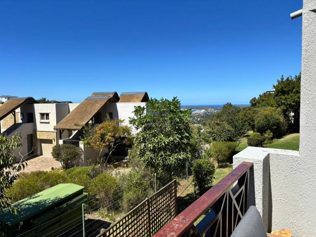 Scenic coastal view with garden buildings and distant ocean horizon