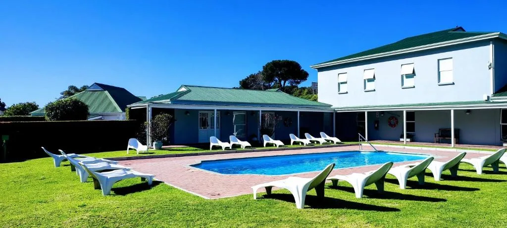 Resort swimming pool with loungers and manicured lawn area