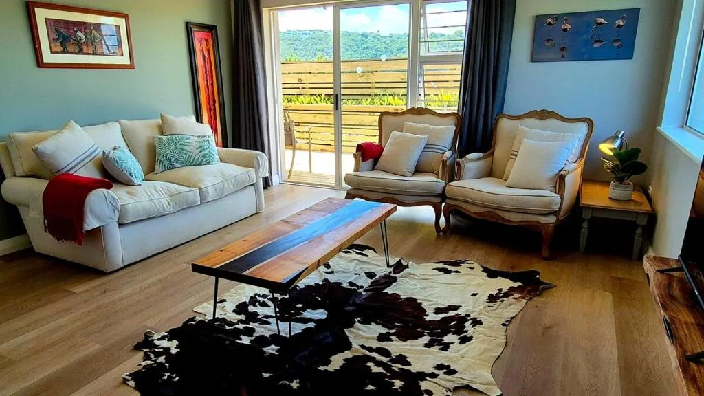 Bright lounge with cream sofas, wooden coffee table, and scenic valley views