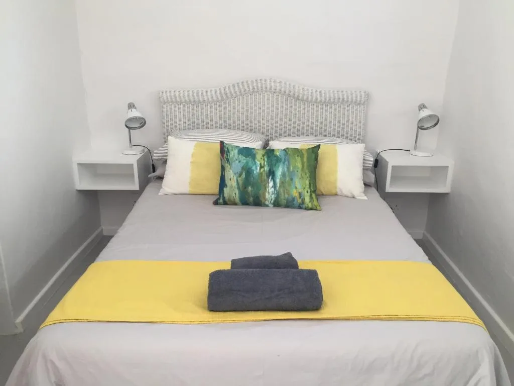Modern bedroom with woven headboard, yellow accents, and coordinated pillows