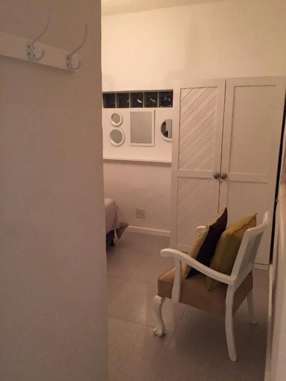 Interior utility area with electrical switches, storage cupboards, and white chair
