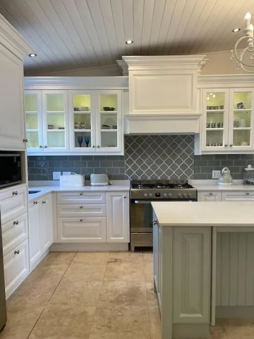 Modern white kitchen with stainless steel appliances and island countertop