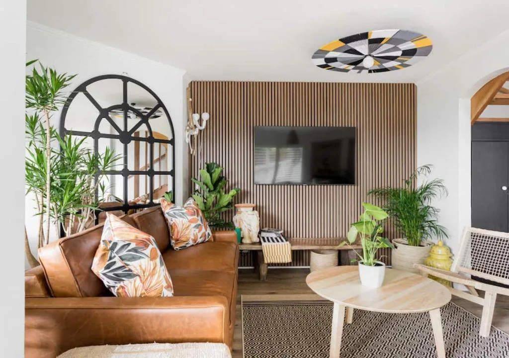 Modern living room with brown leather sofa and wall-mounted television