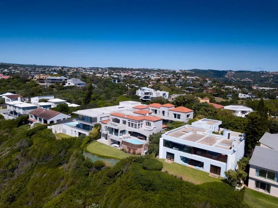 Aerial view of villa nestled in lush hillside landscape with scattered homes