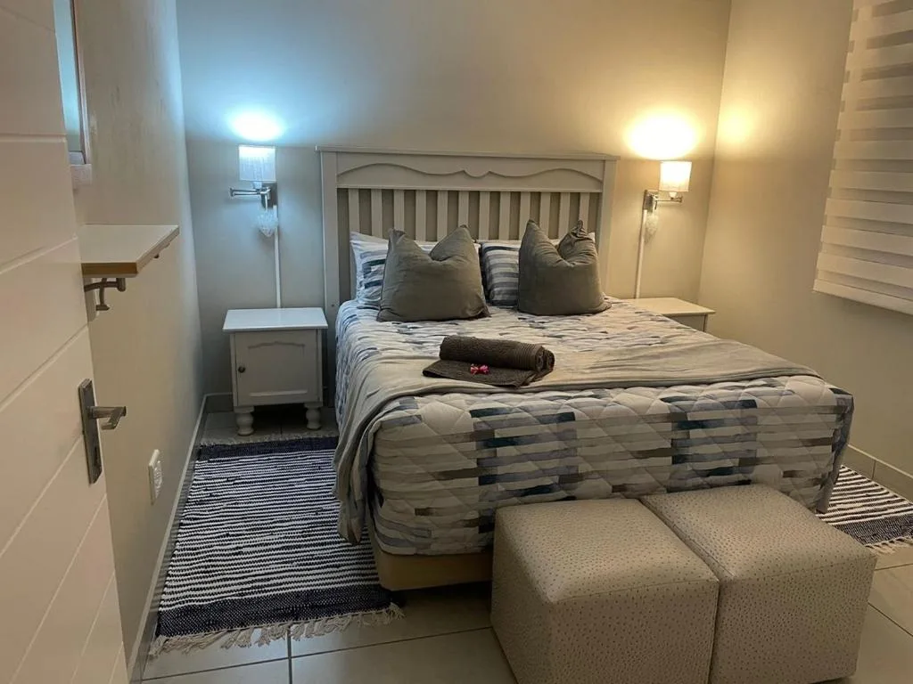 Comfortable bedroom with queen bed, striped bedding, and warm lighting