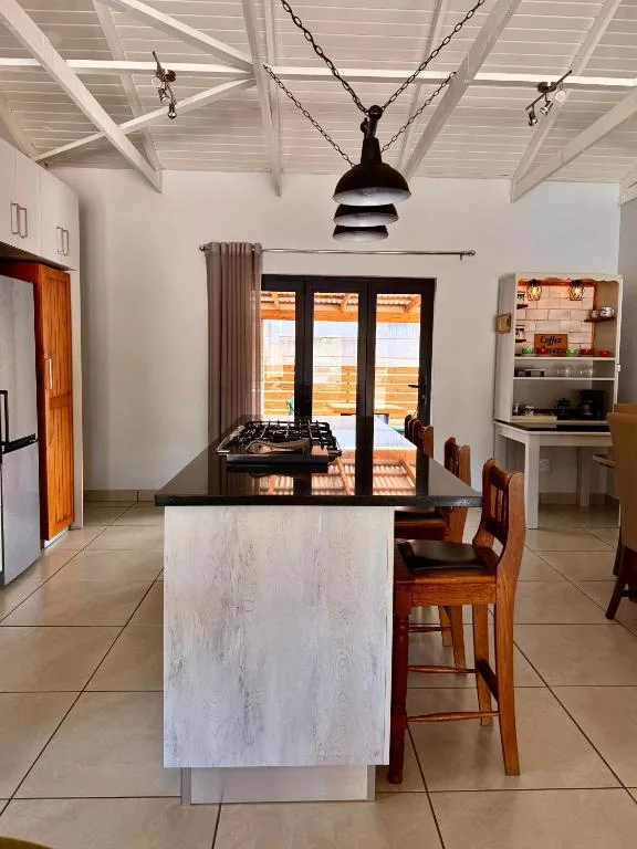 Modern kitchen with island counter, gas cooktop, and wooden bar seating