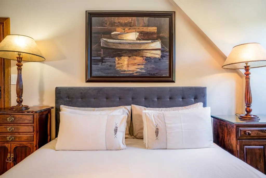 Elegant bedroom with white linens, upholstered headboard, wooden nightstands