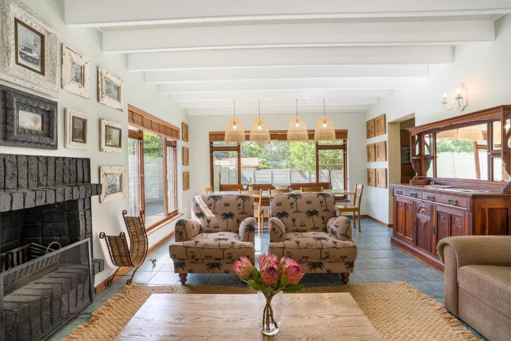 Spacious lounge with palm-patterned armchairs, fireplace, and large windows