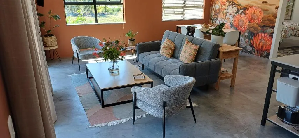 Spacious lounge with grey sofa, armchairs, and coffee table