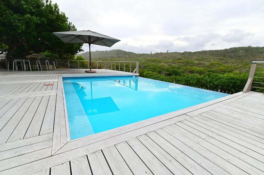 Stunning infinity pool overlooking lush forested hills with wooden deck