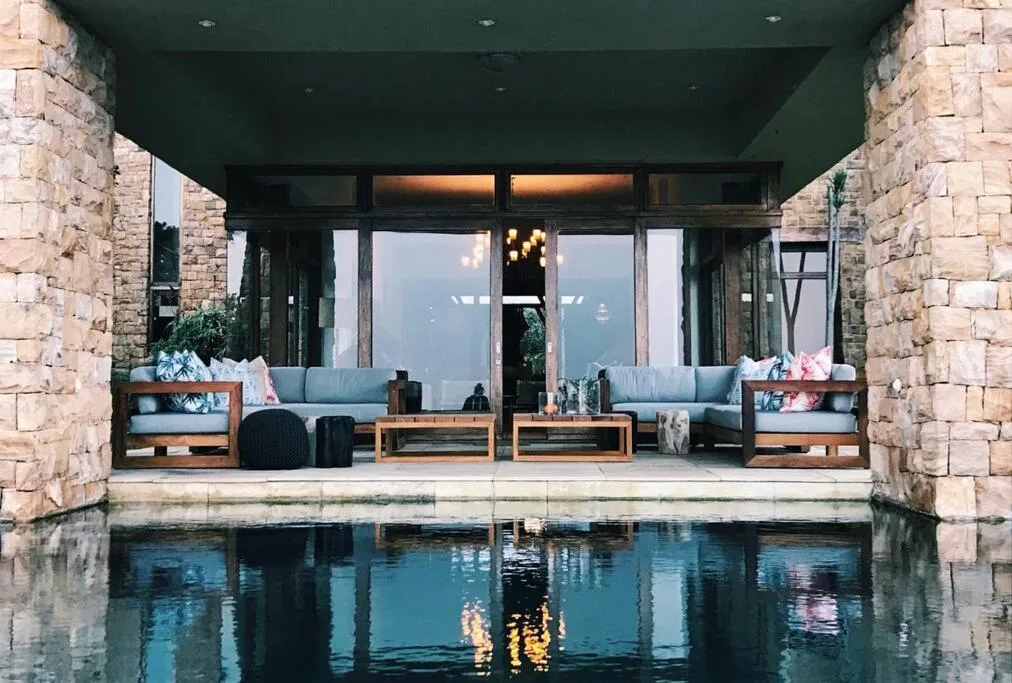Modern poolside lounge area with comfortable seating and mountain views