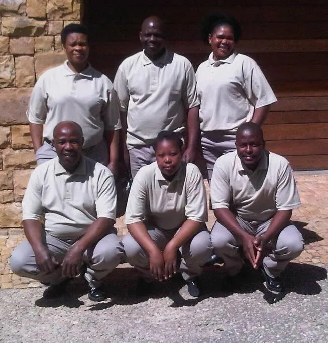 Staff team members posing outside the villa entrance