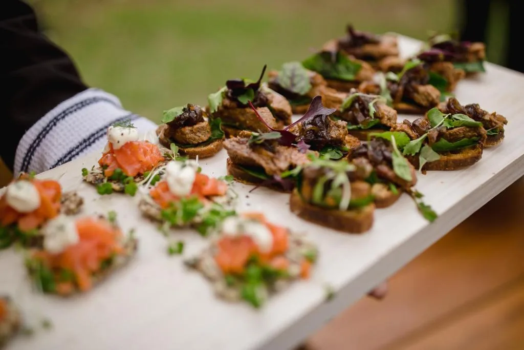 Gourmet appetizers plated with fresh herbs and salmon garnish outdoors