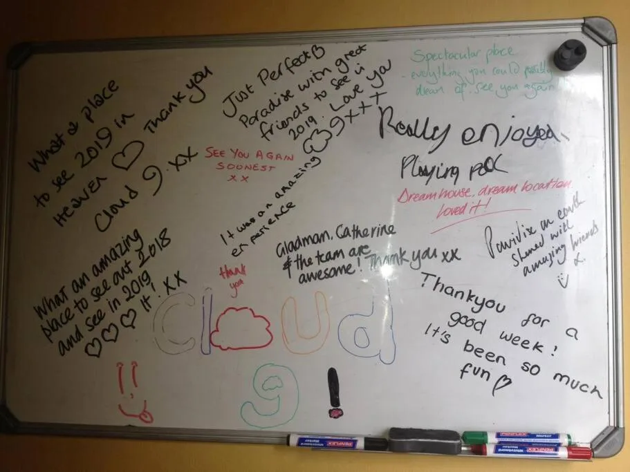 Guest feedback whiteboard with handwritten compliments and thank you messages from visitors