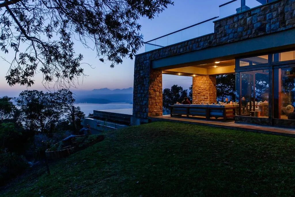 Twilight vista across lagoon with mountains beyond modern villa
