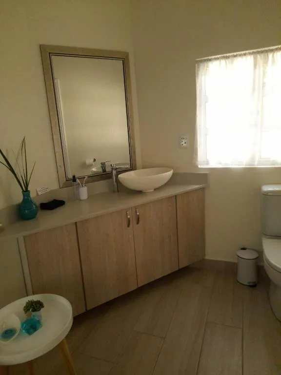 Modern bathroom with wooden vanity, vessel sink, and large mirror