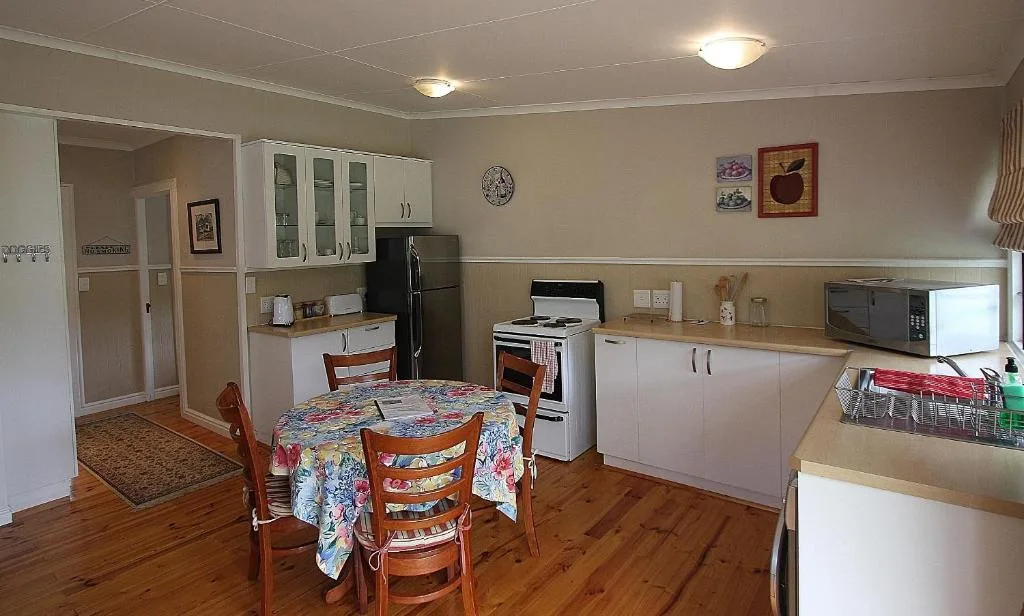 Spacious kitchen with dining table, appliances, and wooden cabinetry