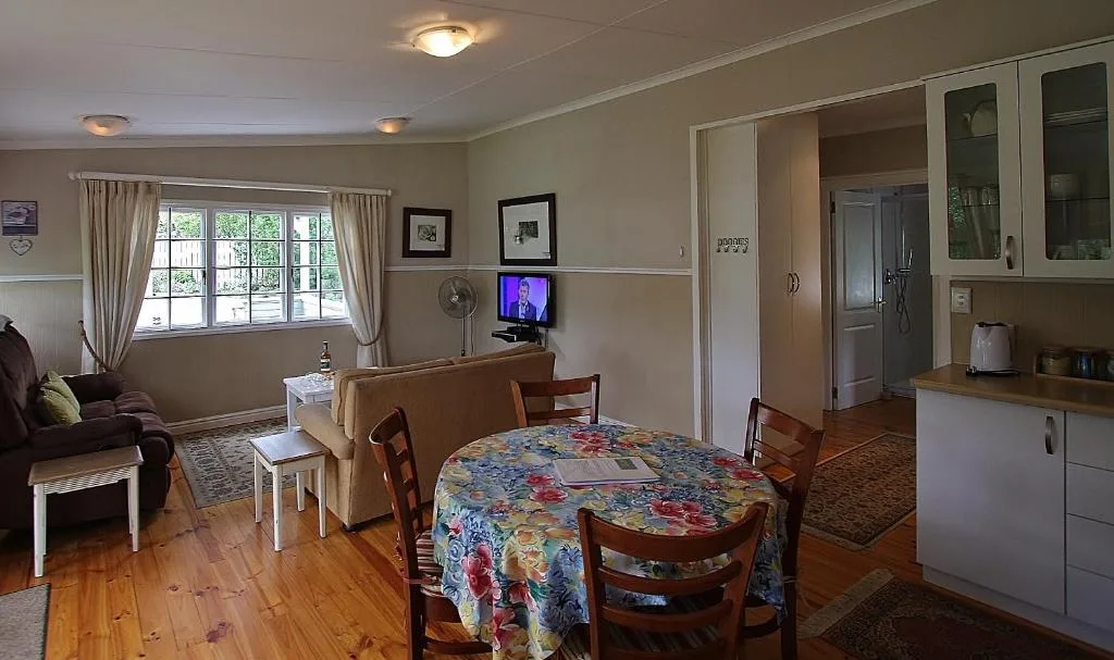 Open-plan living area with dining table, sofa, and television entertainment setup