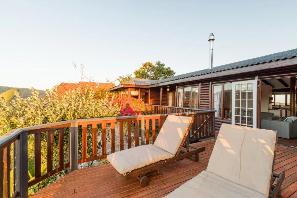 Wooden deck with lounge chairs overlooking garden and hills