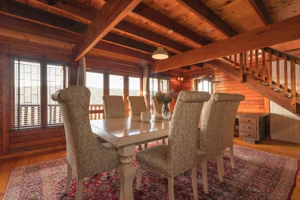 Elegant dining room with wooden beams and mountain views through large windows