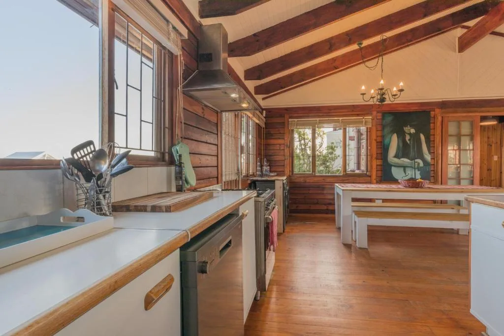 Spacious open-plan kitchen with wooden beams and white countertops
