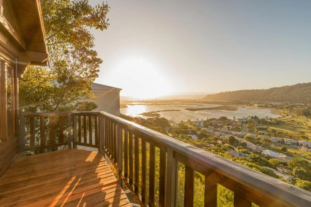 Expansive lagoon and town vista from elevated wooden deck at golden hour