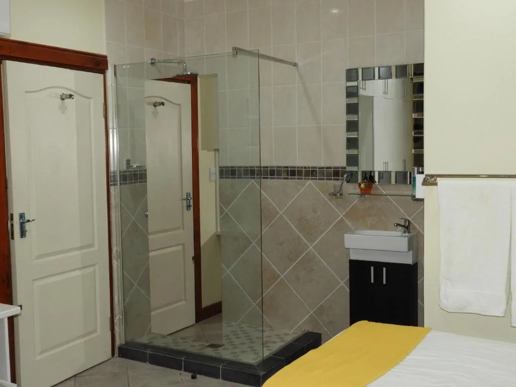 Spacious modern bathroom with large glass shower enclosure and vanity