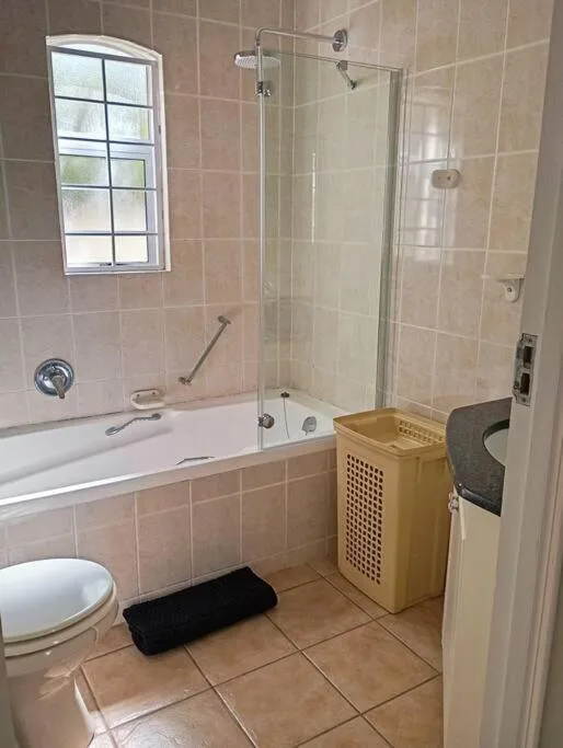 Bathroom with bathtub, shower enclosure, toilet, and window